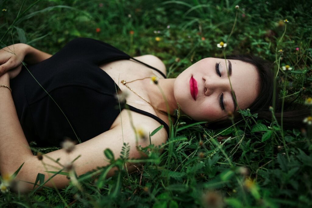 Frau schläft im Gras