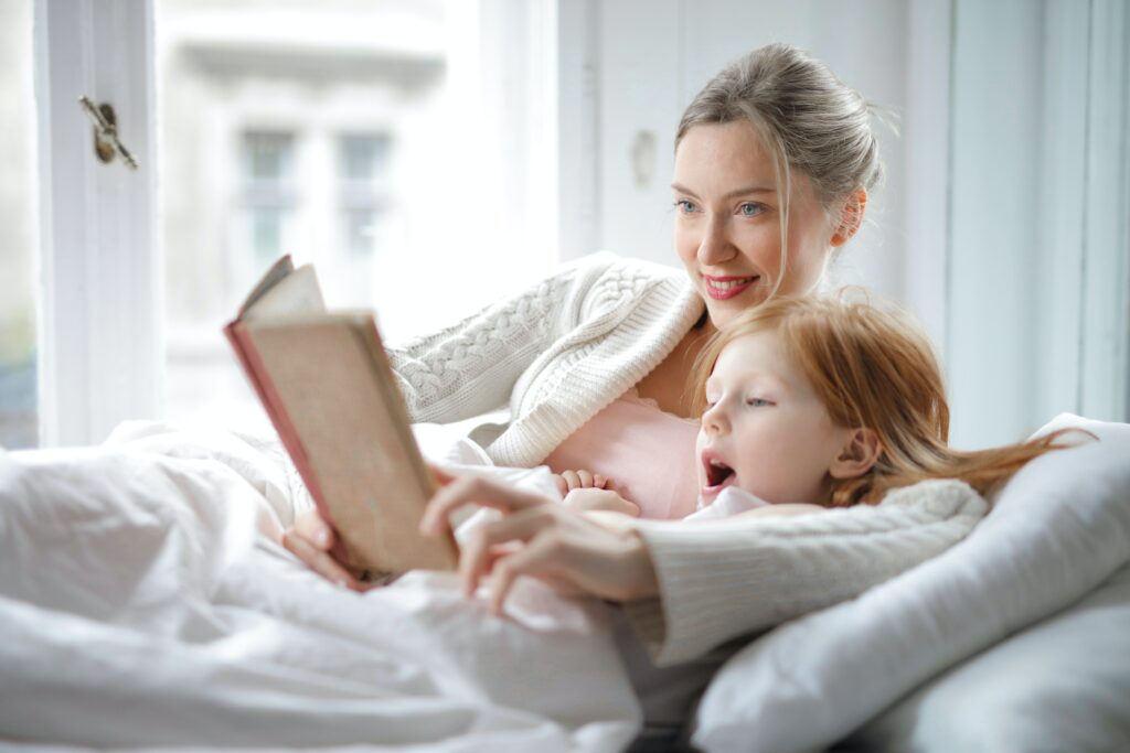 Mama liest mit Kind im Bett