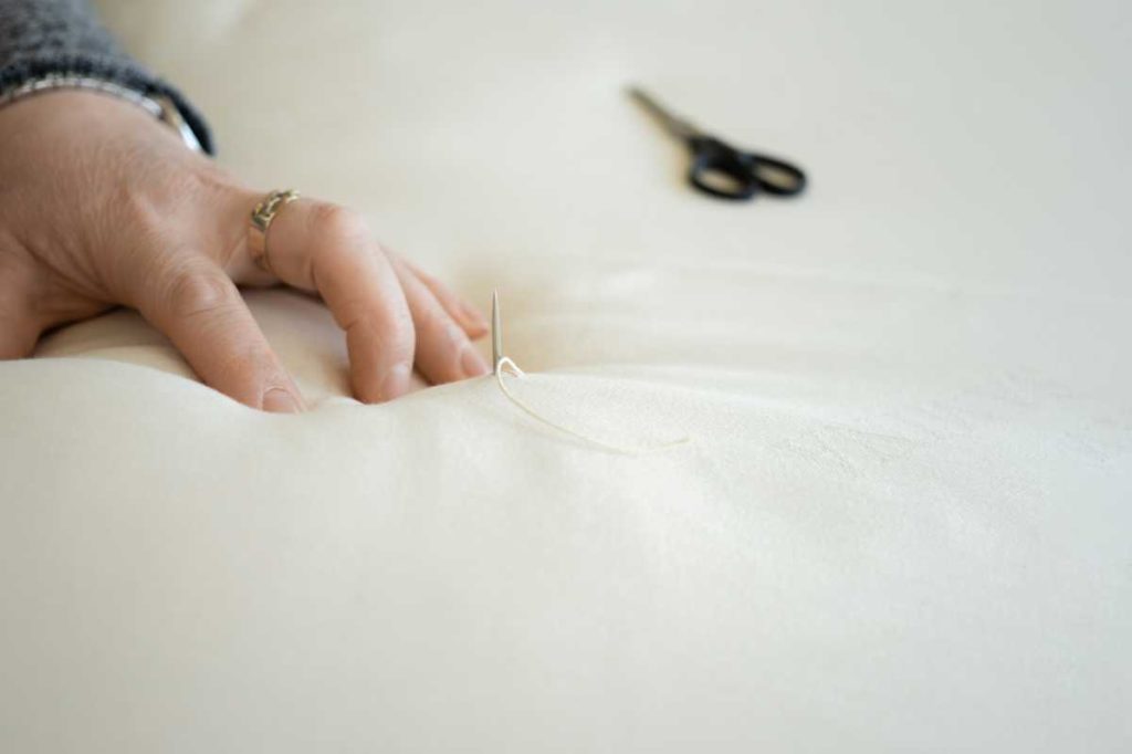 Handarbeit Kreuzstich mit Nadel durch die Decke