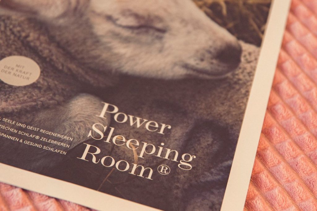 Broschüre mit POWER SLEEPING ROOMS auf einem Bett im Posthotel AH
